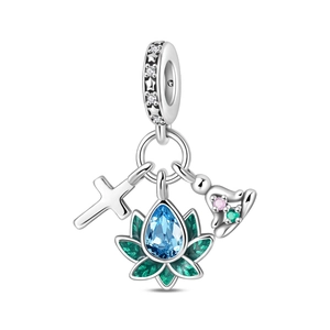 Macro shot of silver charm featuring a cross, blue gem teardrop, and celestial star bail