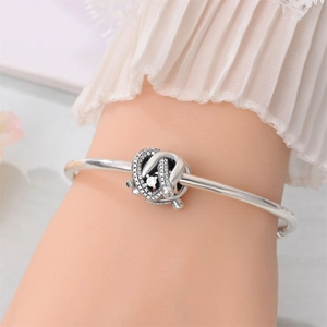 Macro shot of a silver knot charm bracelet with sparkling pave-set cubic zirconia crystals