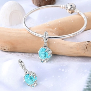 Makroansicht des Silberarmbands mit blauen Schneeflockenanhängern und Sternverschluss