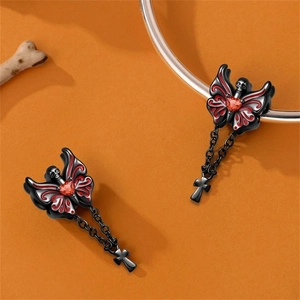 Macro-detail van gotische vlinder-schedelbedel met rood hart zirkoon en kruis aan armband