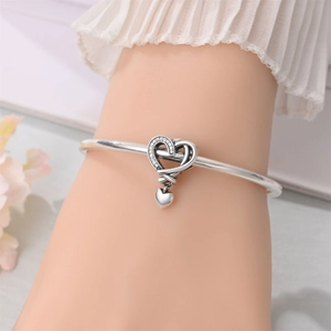 Detailed view of silver-plated heart charm with sparkling stones on elegant bracelet