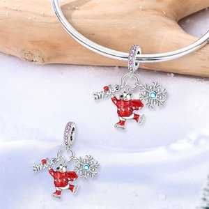 Detalle del dije de oso polar de plata con suéter rojo esmaltado y copo de nieve