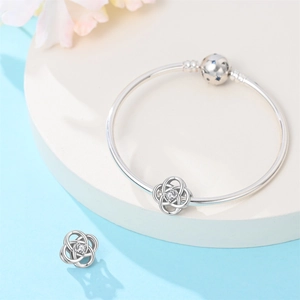 Silver-plated knot charm bracelet with sparkling zircon and star clasp detail
