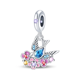 Macro view of a bird and flower charm with blue pear-shaped stone and colorful zircon