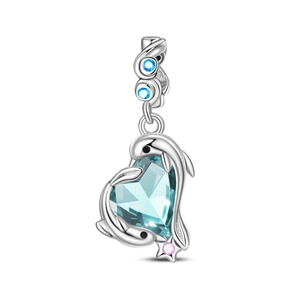 Makroaufnahme von Silber-Delfin-Charm mit herzförmigem blauem Stein und Edelsteinen