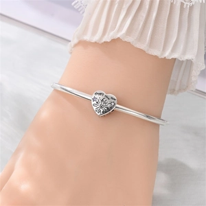 Dettaglio charm a cuore su bracciale d'argento con incisione Happy New Year e cristalli