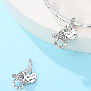 Detail of silver heart infinity charm with sparkling crystals and 'As you wish' engraving
