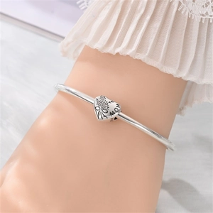 Dettaglio del bracciale rigido in argento S925 con ciondolo a cuore MOM al polso