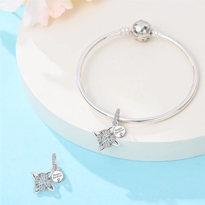 Detailed shot of silver charm bracelet with celtic knot pendants and Happy Forever engraving