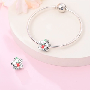 Dettaglio del charm a forma di cane con cuore rosso su bracciale a maglia serpente