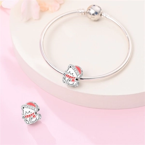 Dettaglio del bracciale con gatto e cappello festivo smaltato su catena serpente