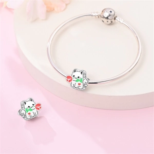 Dettaglio del charm gatto in argento con smalto bianco e rosa rossa su un bracciale
