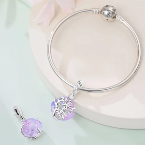 Detailed macro view of silver charm bracelet with purple glass beads and zircon accents