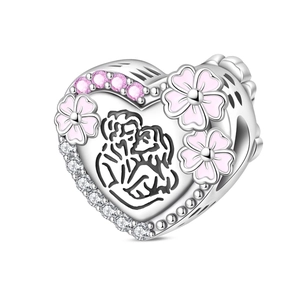 Detailed view of silver heart charm with pink enamel flowers and hugging couple engraving