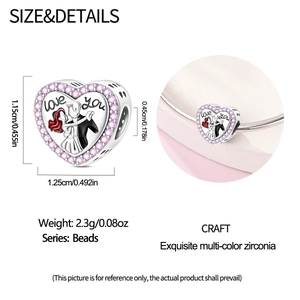 Macro detail of heart charm with dancing couple engraving and pink cubic zirconia stones