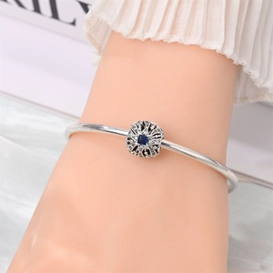Close-up of silver-plated bracelet with hollow star charm and blue gemstone detail
