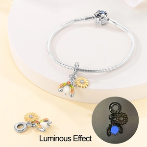 Luminous silver snake chain bracelet with bee sunflower charm showing night glow effect