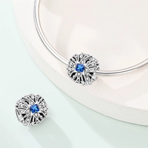 Macro detail of silver star charm with blue zircon stone for DIY beaded bracelets
