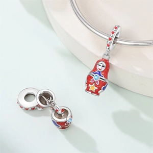 Detailaufnahme eines russischen Matroschka-Anhängers mit Zirkonia auf einem Armband