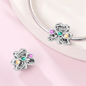 Macro shot of silver clover charm with pink stones and Family Best Ever engraving