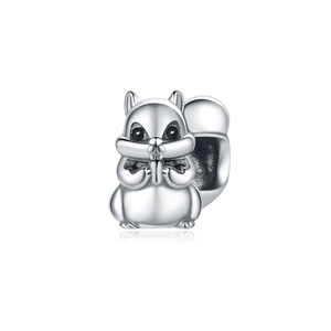 Detailed macro view of squirrel animal charm in silver plated metal with nut detail