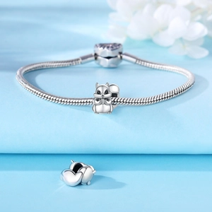 Silver squirrel charm bead on a snake chain bracelet with heart clasp on blue background