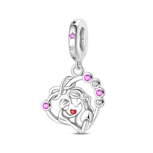 Macro shot of silver mother and child heart charm with pink gems and red enamel
