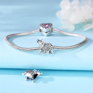 Detailed view of silver snake chain bracelet featuring a carved elephant charm with heart clasp