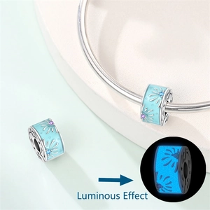 Close-up of luminous blue enamel flower charm with glowing effect in the dark