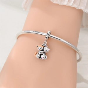 Detailed view of silver charm bracelet with cat duo pendant and LOVE engraving