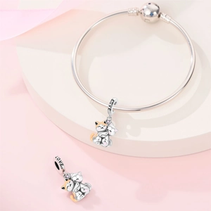 Macro shot of silver cat charm with pink heart zircon and LOVE engraving on bracelet