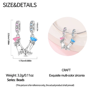 Macro detail of hand-holding charm bead with pink and blue enamel and colorful zircons