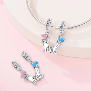 Detail of silver holding-hands charm with pink and blue enamel and sparkling zircon stones