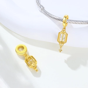Detailed view of a gold lantern charm with hollow design and sparkling star pendant