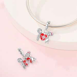 Macro view of silver-plated boy and girl charm with red enamel heart and pink zircon