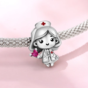 Macro shot of silver cartoon nurse charm with a pink heart zircon on a snake chain
