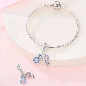 Macro view of silver snake chain bracelet with blue and pink floral enamel heart charms