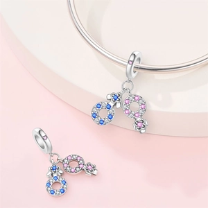 Macro detail of silver plated charms with pavé cubic zirconia in gender symbols style