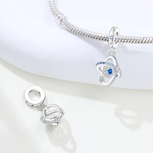 Detailed close-up of cosmic planet pendant with blue stones and star engravings on silver