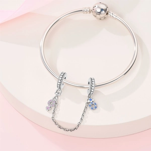 Detail of silver bangle with blue star clasp and linked male and female symbol charms