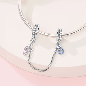 Detail of silver safety chain with heart charms and pink blue zircon gender symbols