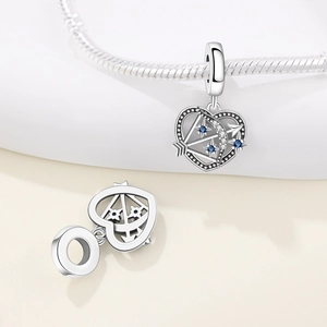 Nahaufnahme von Herzanhänger mit Pfeil und blauem Zirkon auf Schlangenarmband