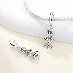 Close-up of silver ballet girl charm with pink crystals on a snake chain bracelet