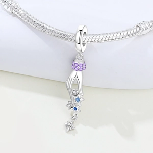 Detailed view of silver star charm with blue and purple zircons on snake chain