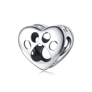 Vista macro di ciondolo a cuore in argento con motivi a zampa scavati per braccialetti