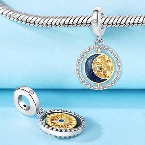Close-up of rotating celestial charm with blue enamel star and golden sun details