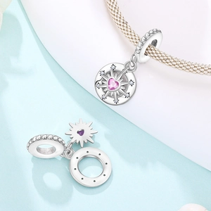 Detail of silver star charm with pink heart zircon and compass engraving for bracelets