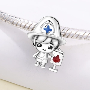 Detailed macro view of a silver fireman charm with blue cross and red flame enamel on a chain