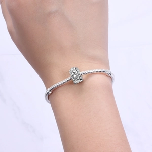 Primo piano di un bracciale con ciondolo in argento e perla floreale con zirconi