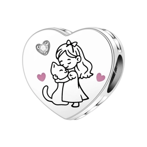 Dettaglio macro dello charm a cuore con ragazza e gatto e smalto rosa tenero